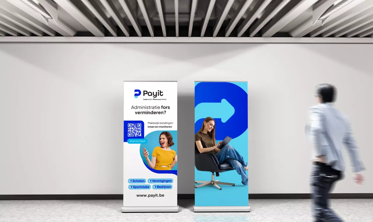 twee rollup banners in payit stijl in een lege ruimte met voorbijlopende man