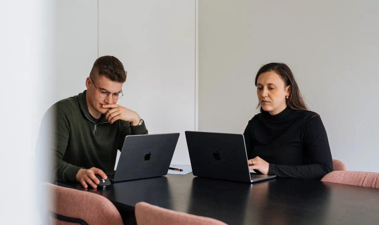Jonathan en elise aan tafel terwijl ze kijken naar hun laptopscherm